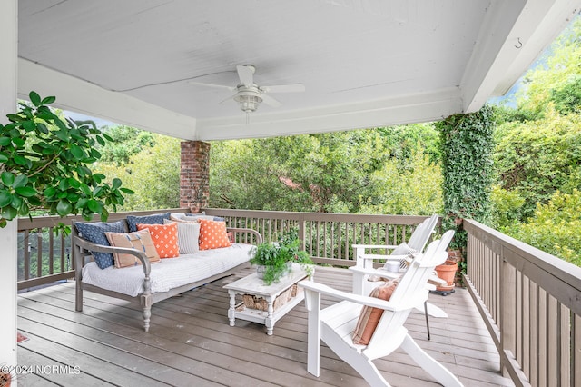 wooden deck with outdoor lounge area and ceiling fan