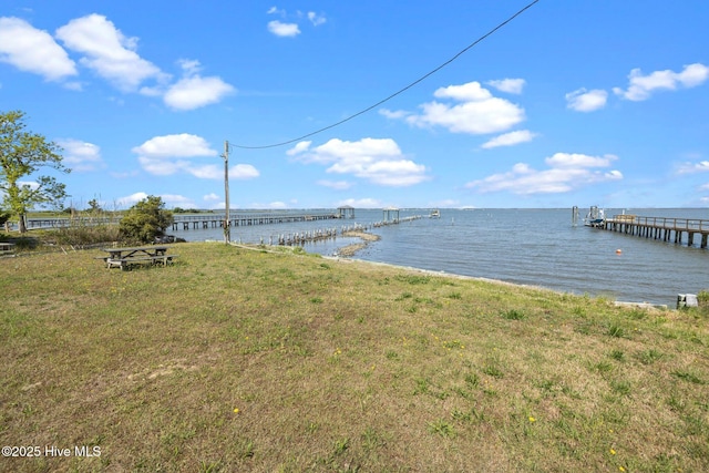dock area featuring a water view and a lawn