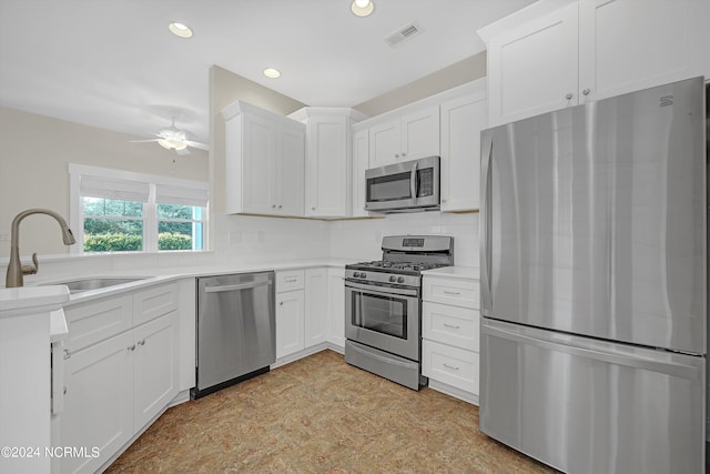 kitchen with decorative backsplash, stainless steel appliances, white cabinetry, and sink