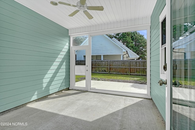 unfurnished sunroom featuring ceiling fan