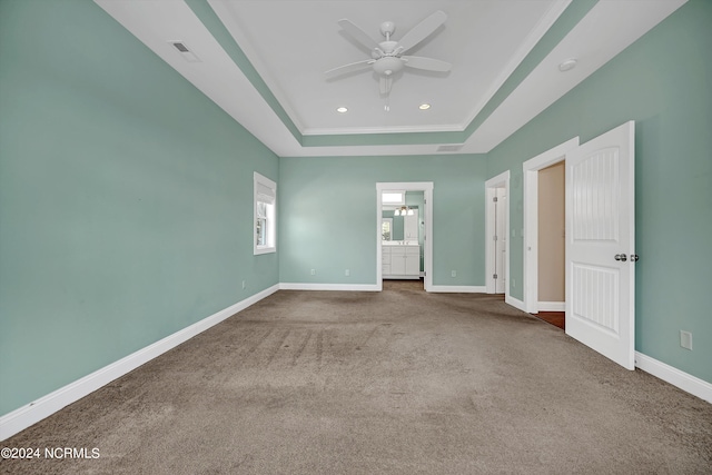 unfurnished bedroom featuring carpet floors, connected bathroom, crown molding, a tray ceiling, and ceiling fan