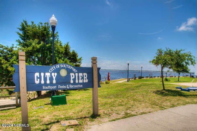 view of property's community with a water view and a yard