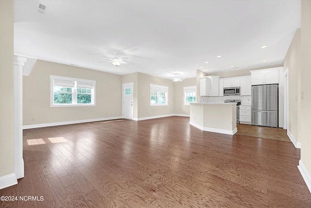 unfurnished living room with ceiling fan and dark hardwood / wood-style flooring