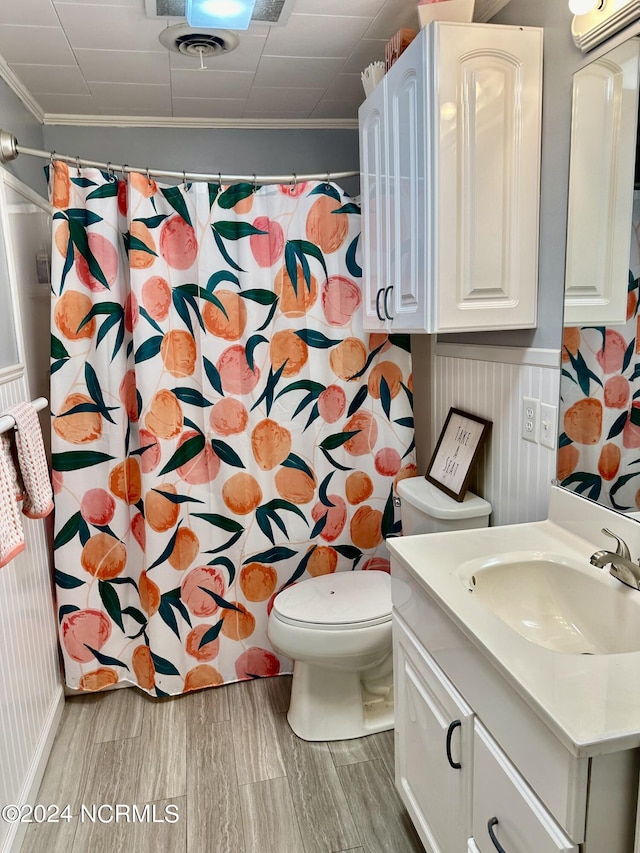 bathroom with ornamental molding, vanity, toilet, and curtained shower