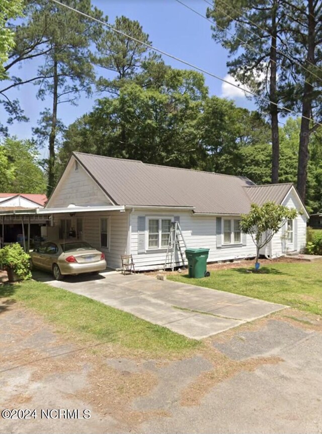 view of front of home with a front lawn and a carport