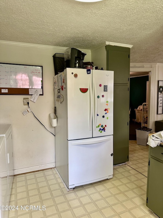 kitchen featuring crown molding, green cabinets, washer and dryer, a textured ceiling, and white fridge