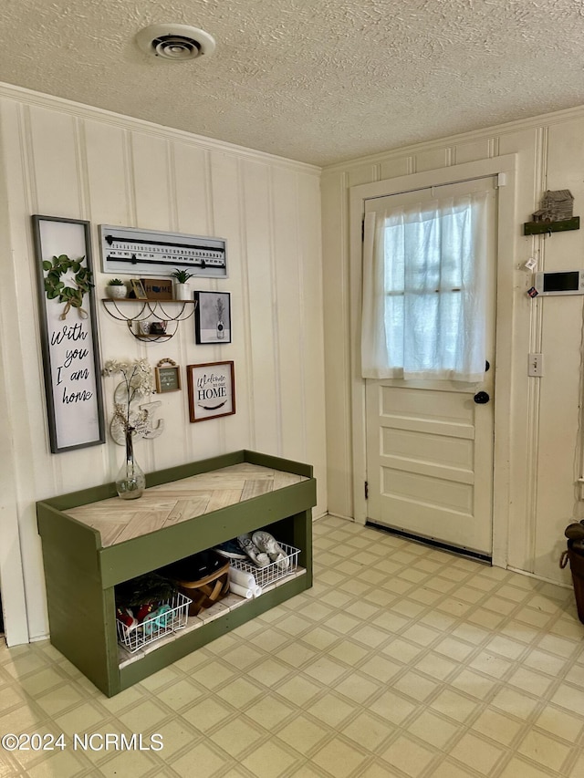 interior space with crown molding and a textured ceiling