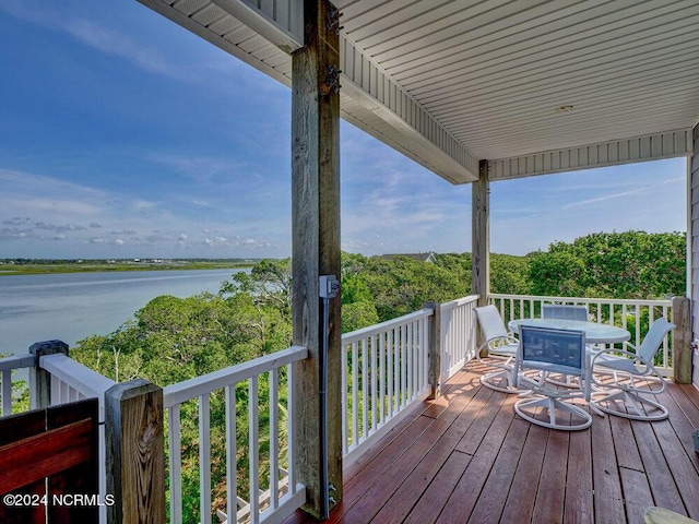 wooden deck featuring a water view and outdoor dining space