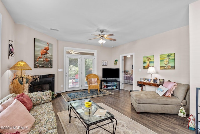 living room featuring ceiling fan and dark hardwood / wood-style floors