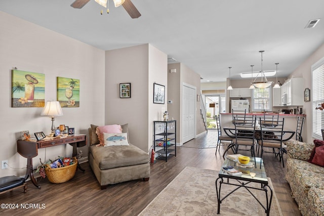 living room with dark hardwood / wood-style floors and ceiling fan