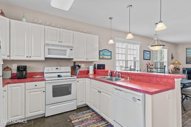 kitchen with white appliances, sink, hanging light fixtures, and kitchen peninsula