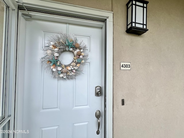 doorway to property featuring stucco siding