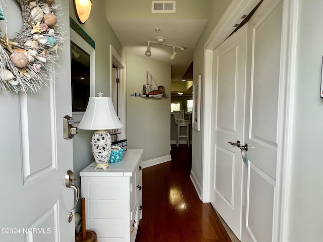 hall featuring track lighting and dark hardwood / wood-style flooring