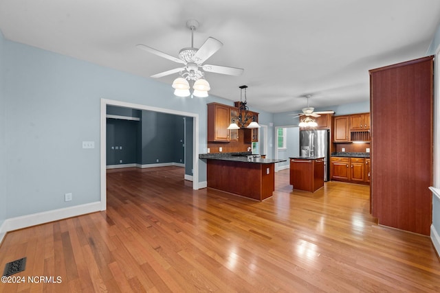 kitchen with a kitchen island, ceiling fan, light wood-type flooring, and hanging light fixtures