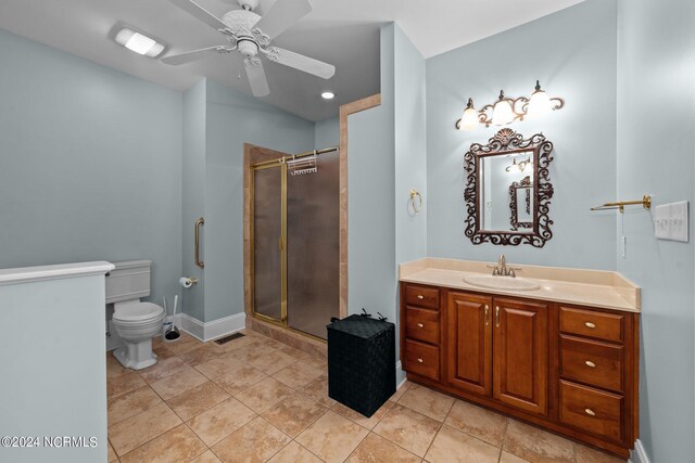 bathroom featuring tile patterned floors, vanity, ceiling fan, toilet, and a shower with door