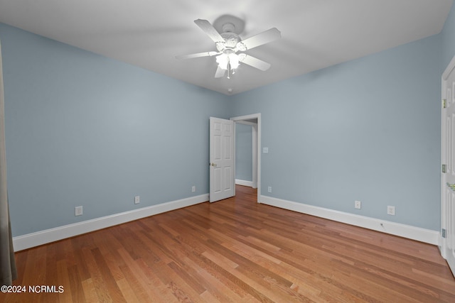 unfurnished room featuring a ceiling fan, baseboards, and wood finished floors