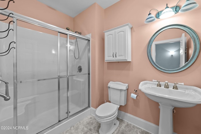 full bathroom featuring a stall shower, baseboards, and toilet