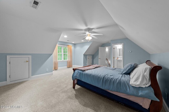 carpeted bedroom featuring ceiling fan, ensuite bathroom, and lofted ceiling