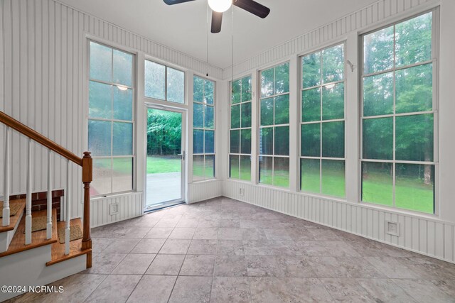 unfurnished sunroom featuring ceiling fan and a wealth of natural light