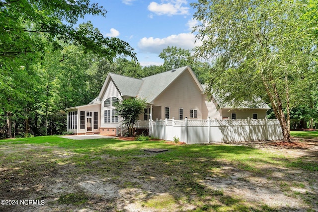 exterior space featuring a yard, a patio, a sunroom, crawl space, and fence