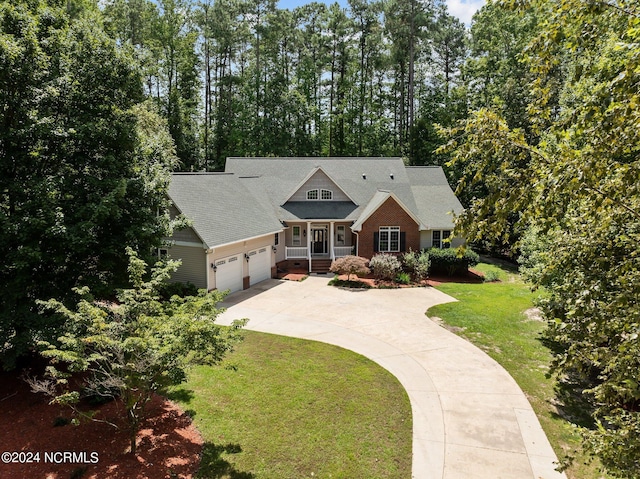 craftsman-style home featuring an attached garage, driveway, and a front lawn