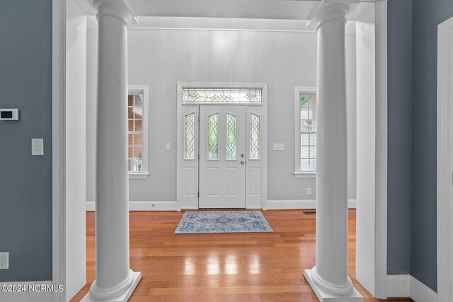 entryway featuring ornate columns and hardwood / wood-style flooring