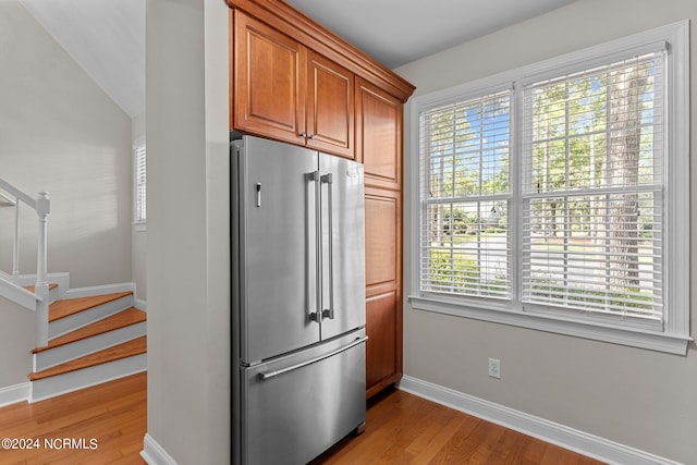 kitchen featuring plenty of natural light, high end refrigerator, and light hardwood / wood-style floors