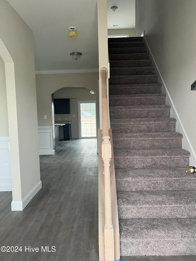 stairs with hardwood / wood-style floors and crown molding