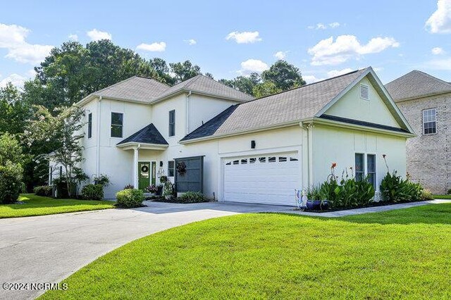 view of front of house featuring a garage and a front lawn