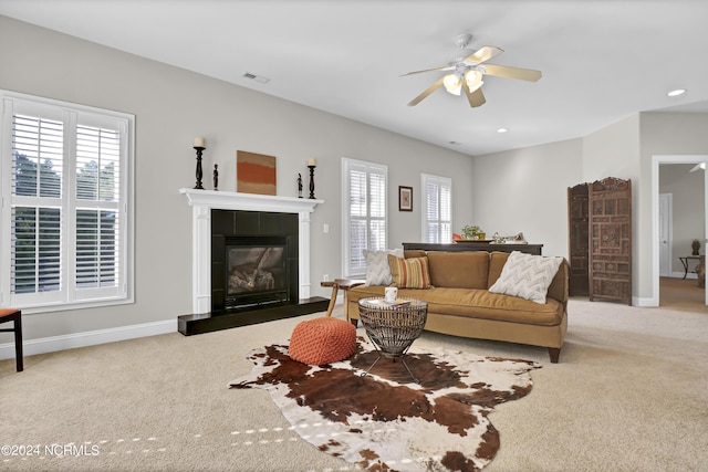 living area featuring light colored carpet, visible vents, baseboards, and a tile fireplace