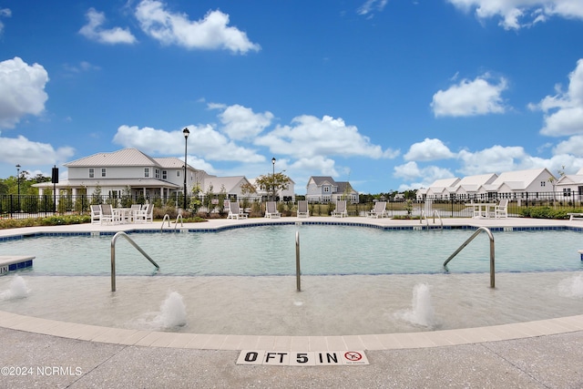 view of swimming pool with pool water feature