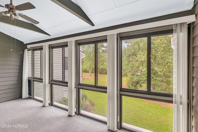 unfurnished sunroom with ceiling fan and lofted ceiling with beams