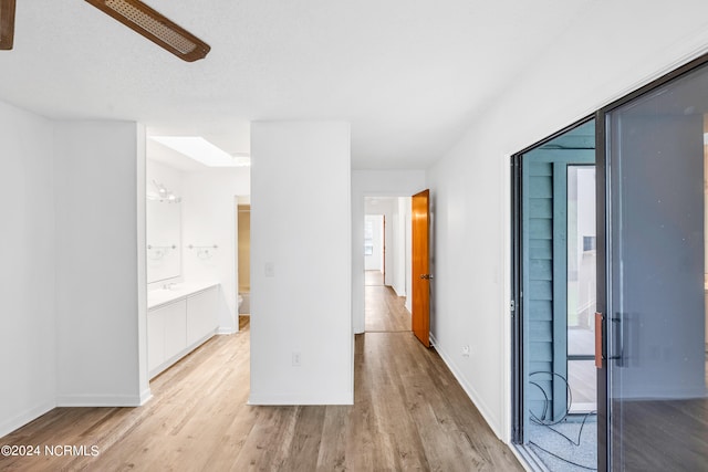 unfurnished room with light wood-type flooring and a textured ceiling