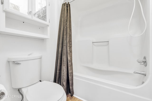 bathroom with shower / bath combo, wood-type flooring, and toilet