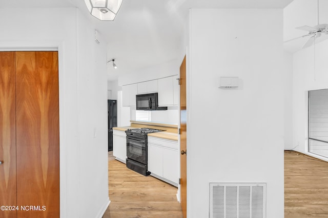 kitchen with black appliances, light wood-type flooring, white cabinets, and ceiling fan