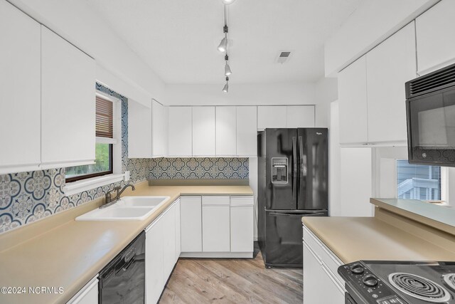 kitchen with decorative backsplash, sink, black appliances, and white cabinetry