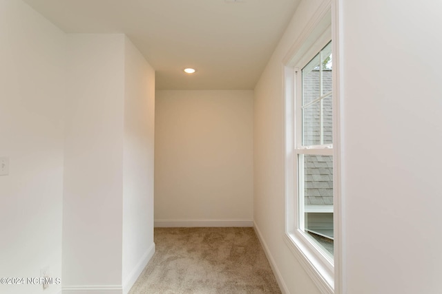 corridor featuring light colored carpet