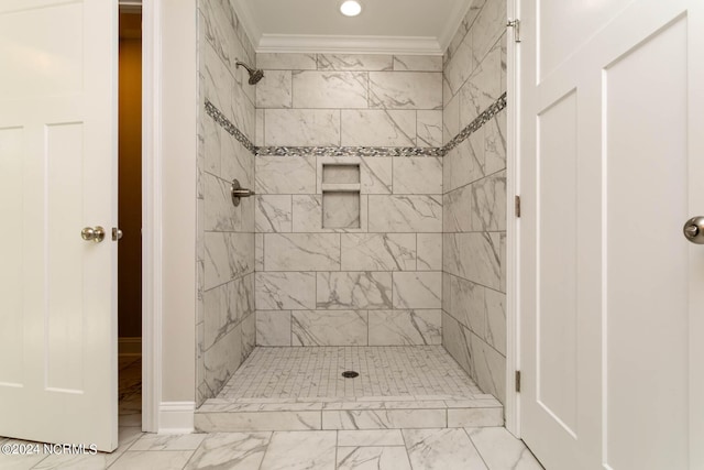 bathroom featuring tiled shower and crown molding