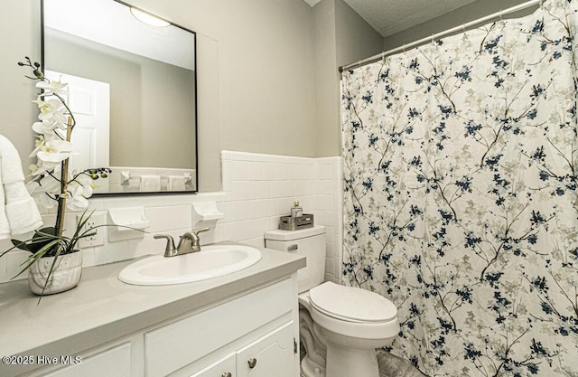 bathroom with vanity, tile walls, toilet, and a shower with shower curtain