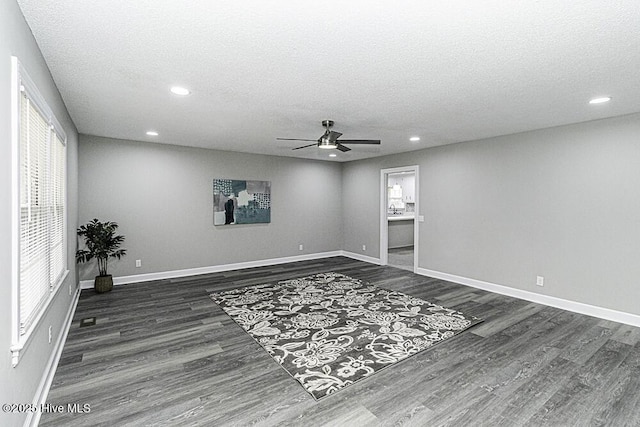 unfurnished room with ceiling fan, dark hardwood / wood-style flooring, and a textured ceiling