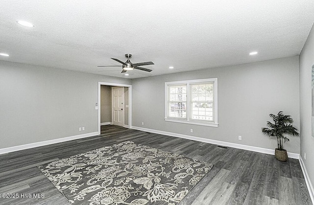 empty room featuring ceiling fan, dark hardwood / wood-style flooring, and a textured ceiling