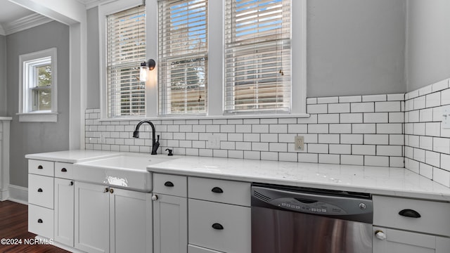 kitchen with light stone countertops, crown molding, sink, and dishwasher