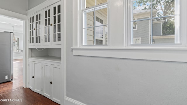 details with hardwood / wood-style floors and stainless steel refrigerator