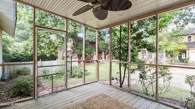 unfurnished sunroom featuring a ceiling fan