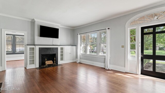 unfurnished living room featuring ornamental molding, hardwood / wood-style floors, and plenty of natural light