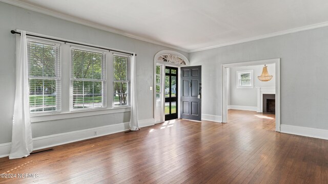 spare room featuring dark hardwood / wood-style flooring and crown molding