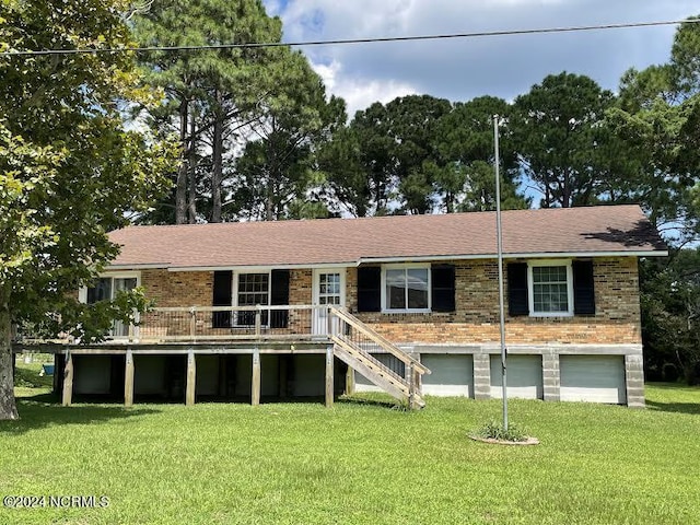 view of front of home featuring a garage, a front yard, and brick siding