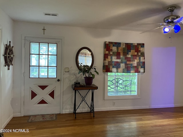 doorway to outside featuring wood finished floors, a wealth of natural light, and baseboards