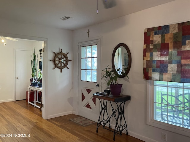 entryway featuring a ceiling fan, visible vents, baseboards, and wood finished floors