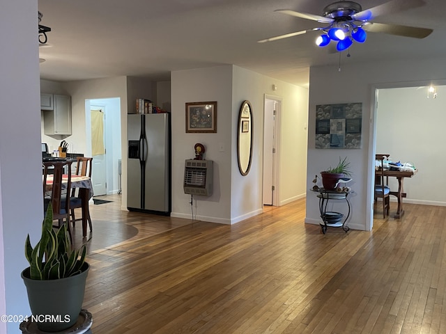 interior space with baseboards, hardwood / wood-style floors, and heating unit